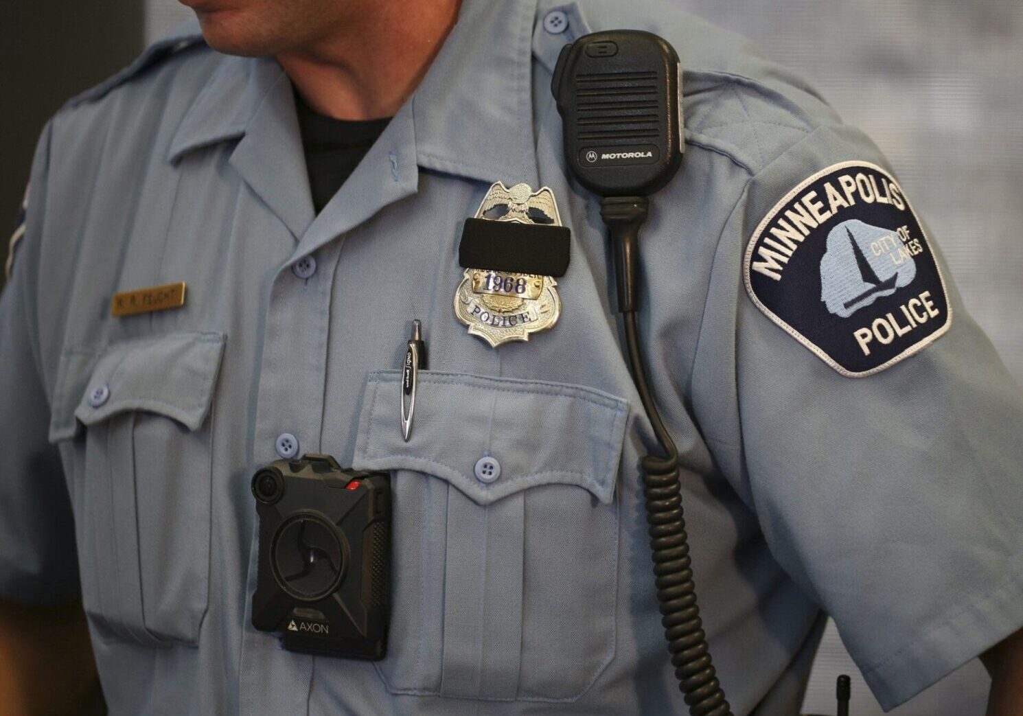 A police officer is wearing his uniform and badge.